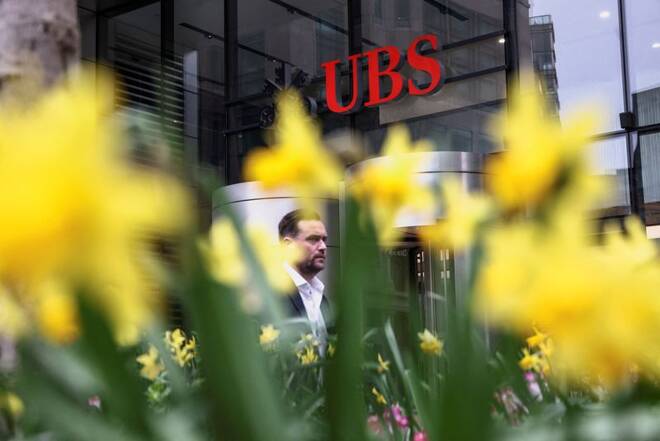 A person walks past the UBS office in London