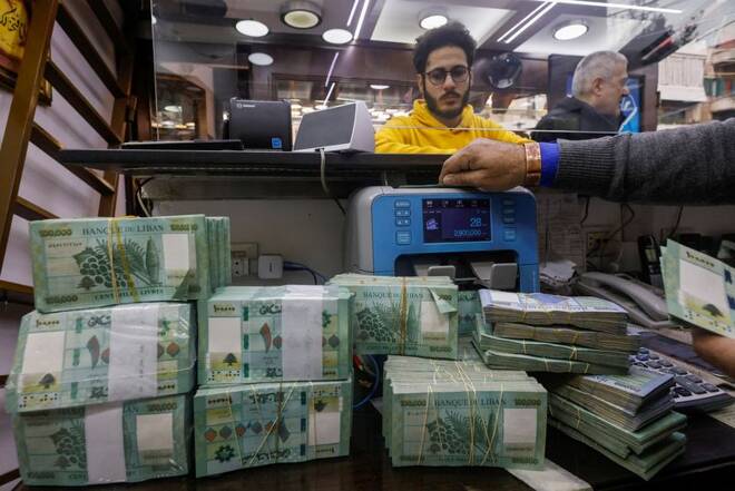 A man counts Lebanese pound banknotes at an exchange shop in Beirut