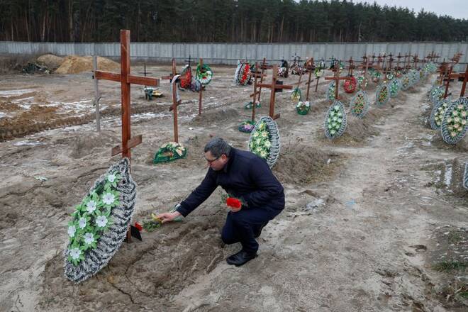 People visit graves of unidentified people, in a day of the first anniversary of Russia's attack on Ukraine, in Bucha