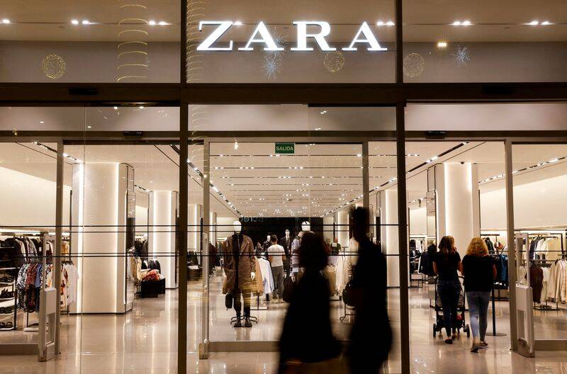Shoppers walk past a Zara clothes store, part of the Spanish group Inditex