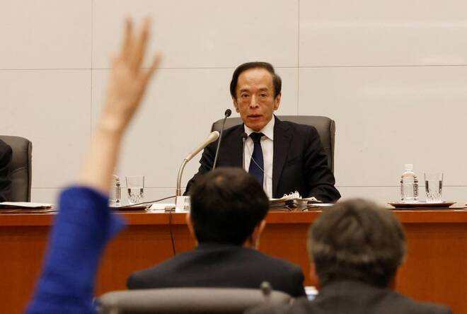 A reporters raises her hand to ask questions to Bank of Japan Governor Kazuo Ueda at a news conference at the bank headquarters in Tokyo