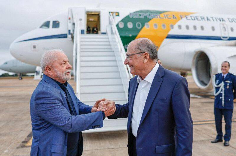 Brazil's President Luiz Inacio Lula da Silva holds the hand of Vice President Geraldo Alckmin as he boards to China in Brasilia