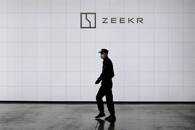 Security guard walks past a sign of Geely's new brand Zeekr at its factory in Ningbo