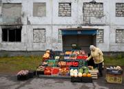 A woman sells fruit and vegetables in a street in the far northern city of Vorkuta