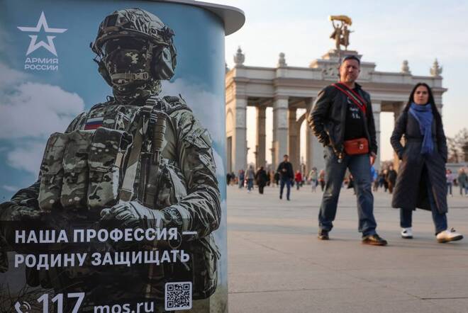 People walk past a desk promoting Russian army service in Moscow