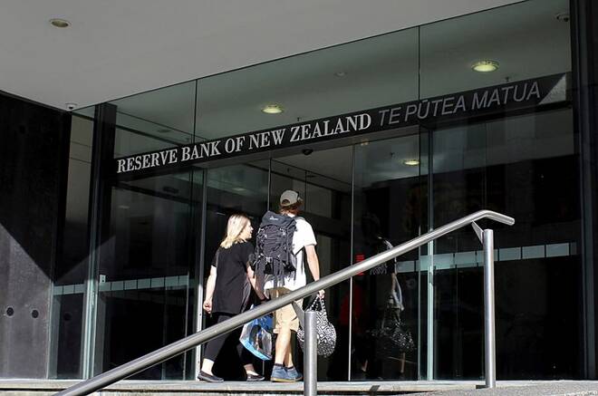 Two people walk towards the entrance of the Reserve Bank of New Zealand located in the New Zealand capital city of Wellington