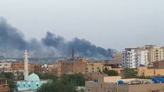 Smoke rises from the tarmac of Khartoum International Airport as a fire burns, in Khartoum