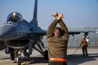 U.S. Air Force airman marshals an F-16 Fighting Falcon aircraft at the 86th Air Base Romania