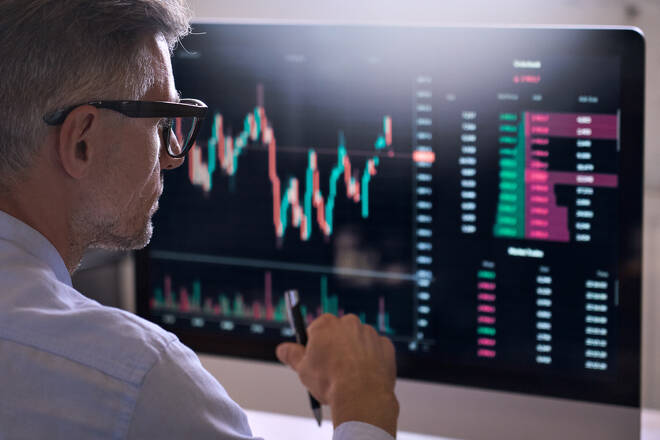 Trader in front of charts. FX Empire