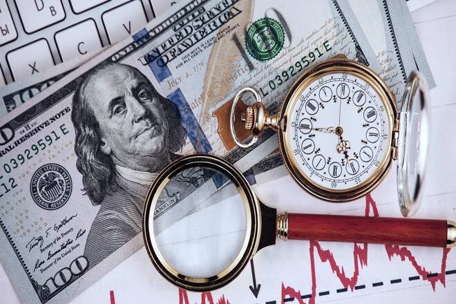 US Dollar, a magnifying glass and an old clock on a keyboard. FX Empire