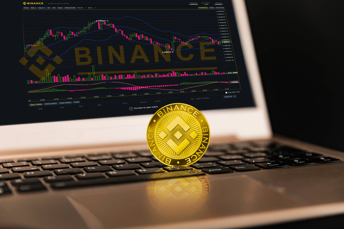 Binance coin in front of laptop. FX Empire