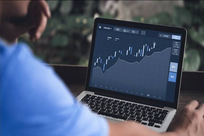 Trading working on the Octa platform with his laptop. FX Empire