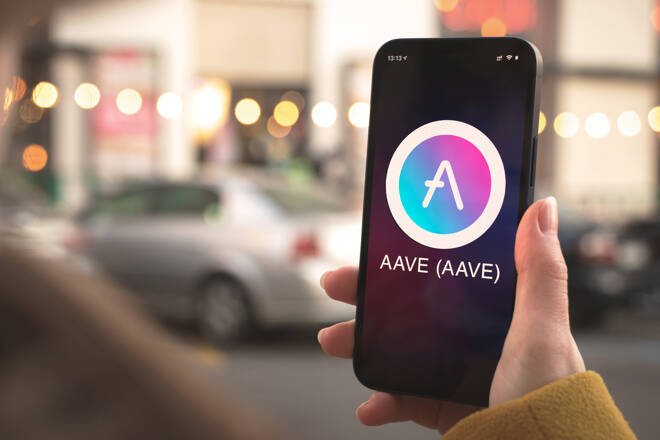 Aave logo on smartphone. FX Empire