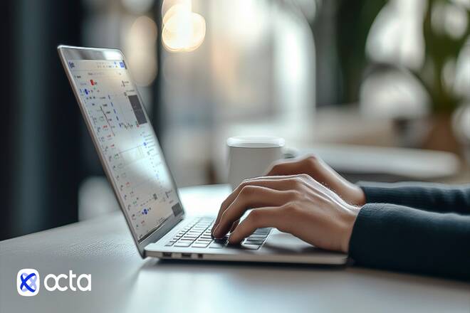 Trader using a laptop and Octa logo. FX Empire