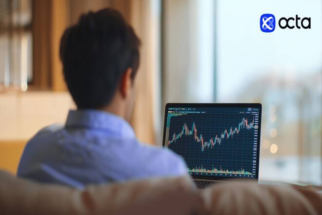 Trader using Octa platform in a laptop. FX Empire