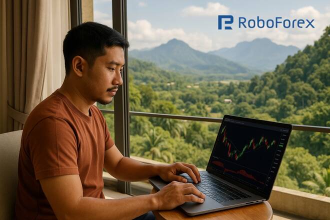 Trader using RoboForex platform in a laptop. FX Empire