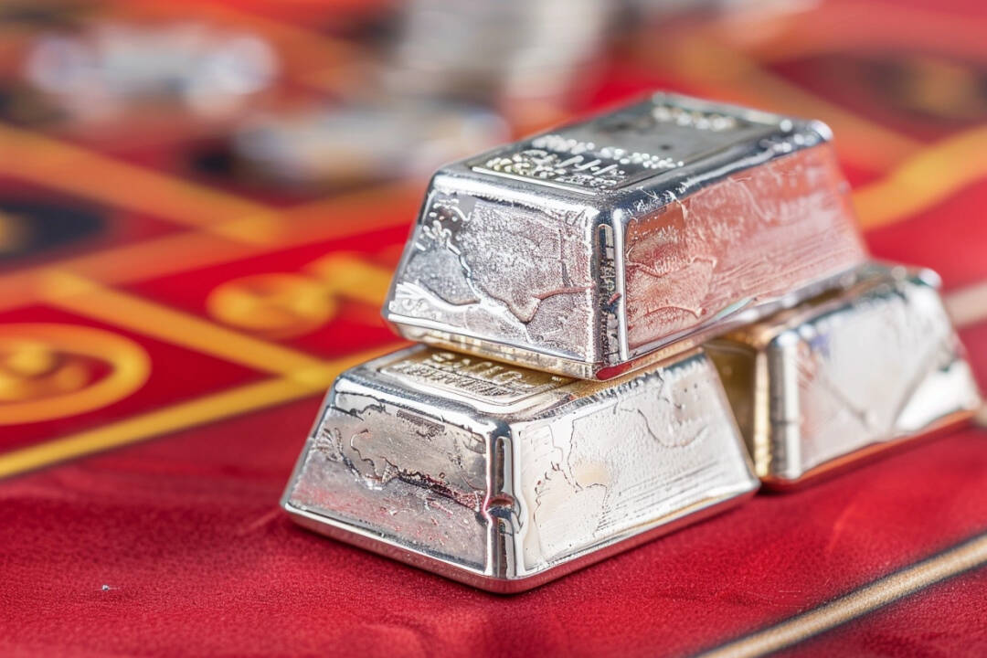 Silver bullion on red background. FX Empire