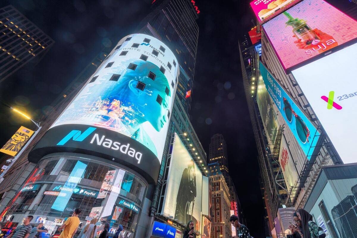 NASDAQ building in Time Square at night. FX Empire