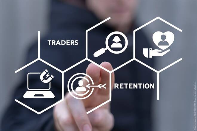 Trader pointing to a screen displaying Traders and Retention. FX Empire
