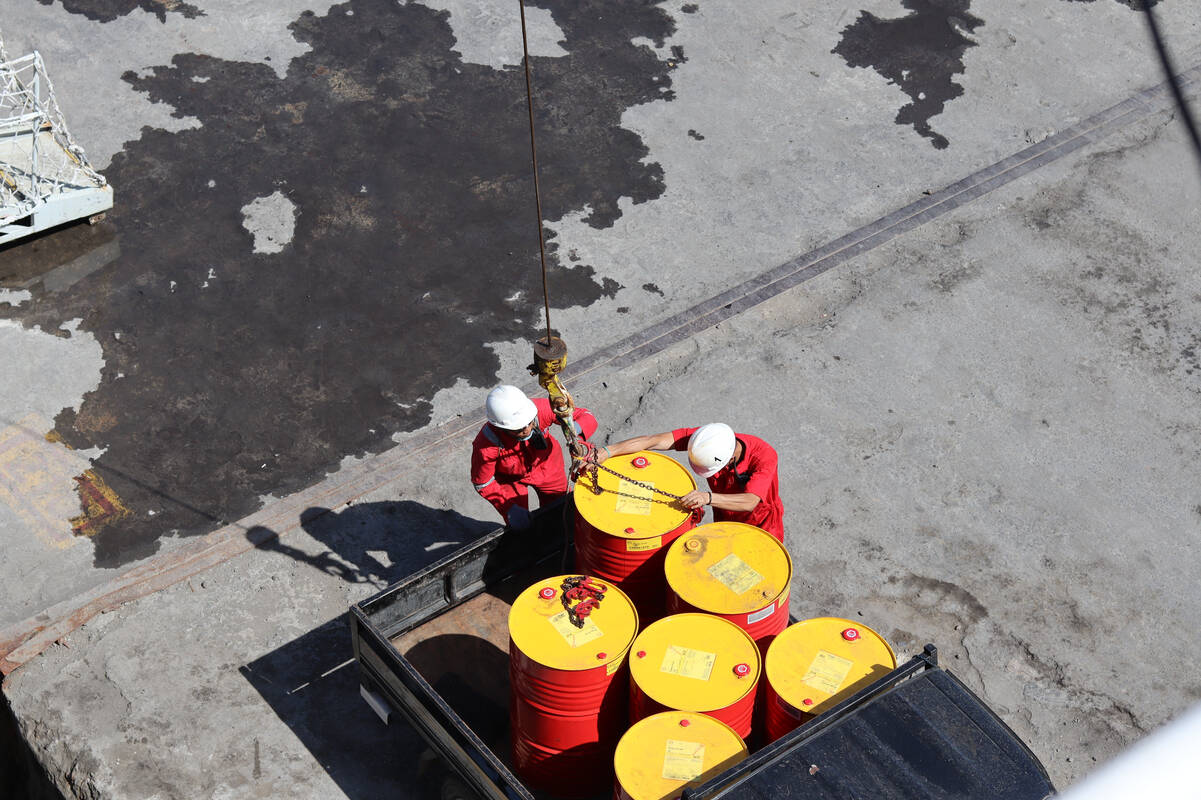Crude oil barrels and workers, FX Empire