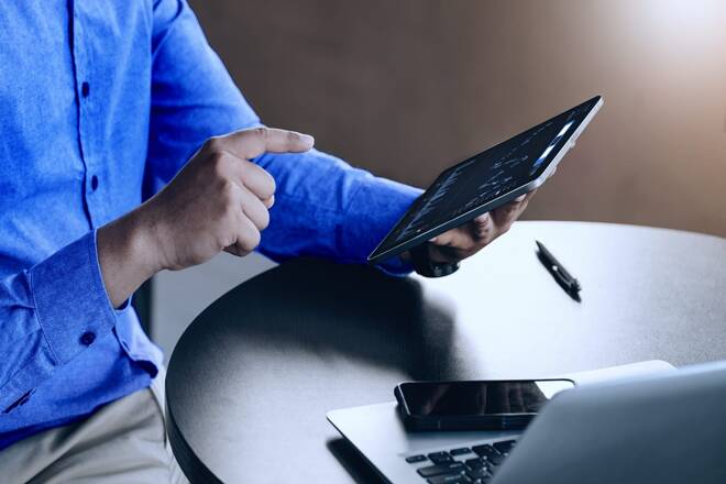 Trader using tablet. FX Empire