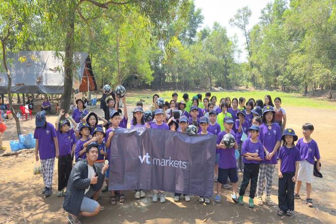 Children from Vietnam, the VT Markets team, and a sign with the broker's name