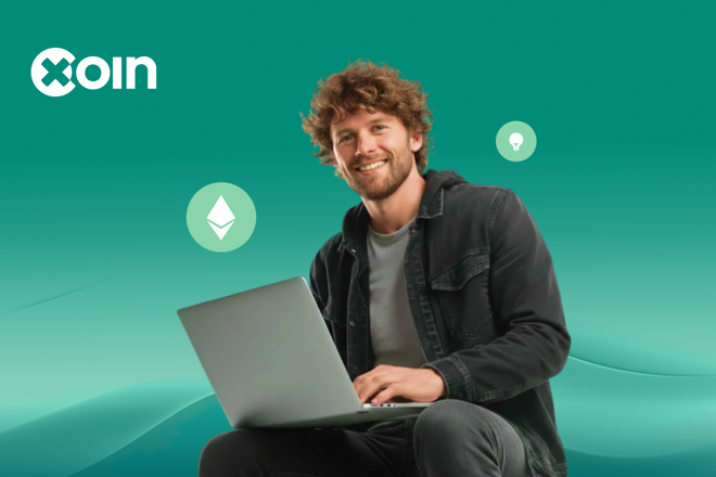 Trader using a laptop and Xcoin logo.