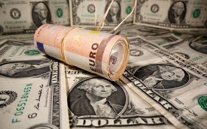 Rolled Euro banknotes are placed on U.S. Dollar