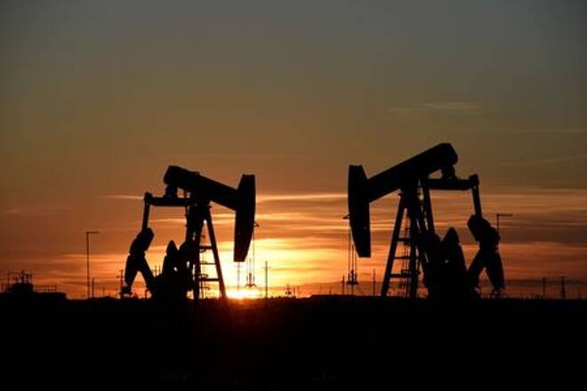 Pump jacks operate at sunset in an oil