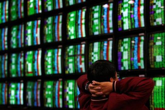 A man looks at stock market monitors in