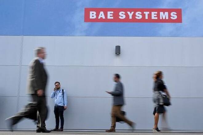 Trade visitors walk past an advertisement for BAE