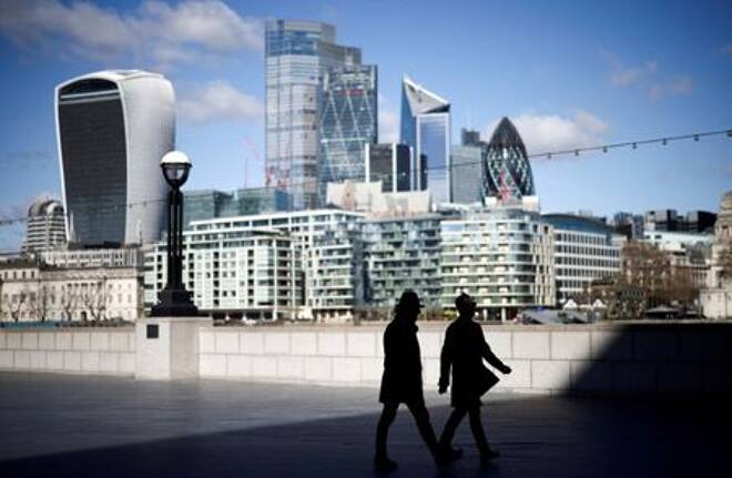 FILE PHOTO: The City of London financial district can be seen as people walk along the south side of the River Thames