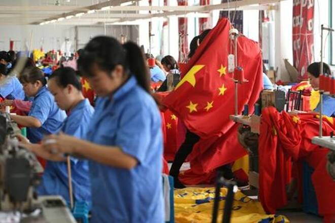 FILE PHOTO: Workers make Chinese flags at a factory ahead of the 70th founding anniversary of People's Republic of China, in Jiaxing, Zhejiang