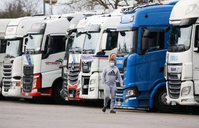 A driver walks past lorries at Ashford International Truck Stop