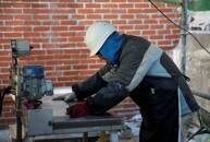 FILE PHOTO: A worker cuts tiles at a construction site of a residential block in the Valdebebas neighbourhood in Madrid