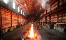 FILE PHOTO: Steam rolls off a slab of steel as it rolls down the line at the Novolipetsk Steel PAO steel mill in Farrell
