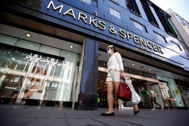 FILE PHOTO: A woman walks past a M&amp;S store at
