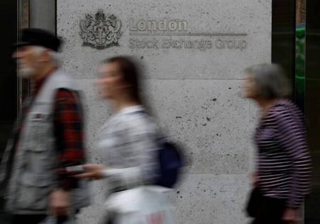 People walk past the entrance of the London Stock Exchange in London