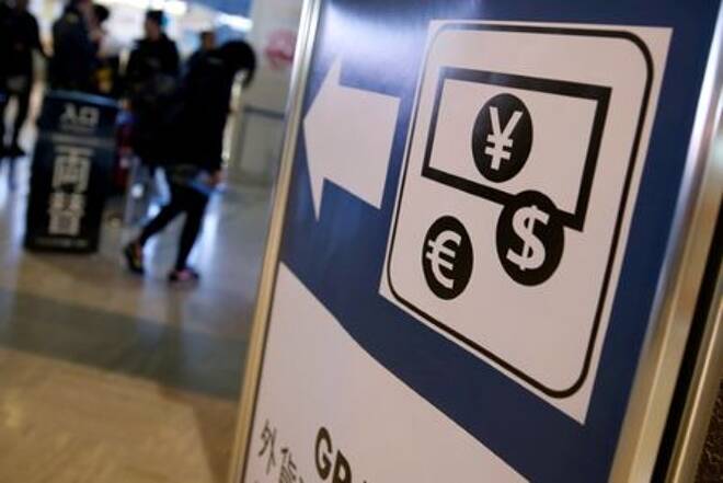 FILE PHOTO: Currency signs of Japanese Yen, Euro and the U.S. dollar are seen on a board outside a currency exchange office at Narita International airport
