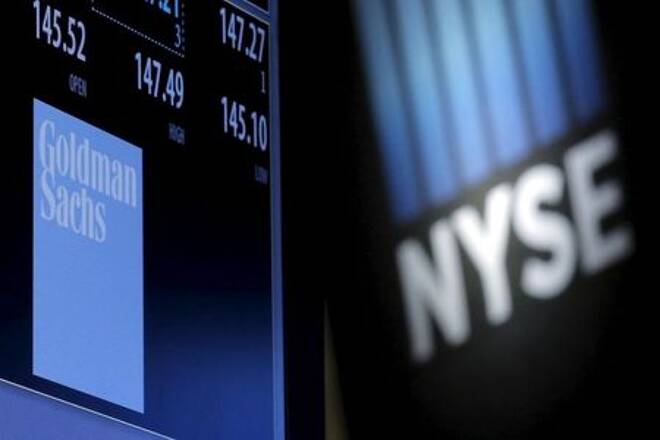 A screen displays the ticker symbol and information for Goldman Sachs on the floor of the New York Stock Exchange