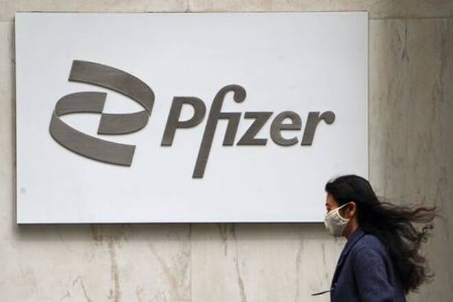 A person walks past a Pfizer logo in