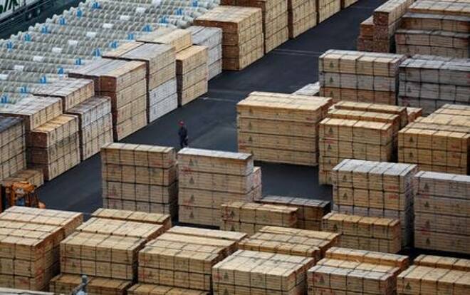 FILE PHOTO: Worker walks among processed timber at a port in Keihin industrial zone in Kawasaki