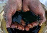 FILE PHOTO: An employee holds a sample of crude oil at the Irkutsk Oil Co-owned Yarakta field in the Irkutsk region