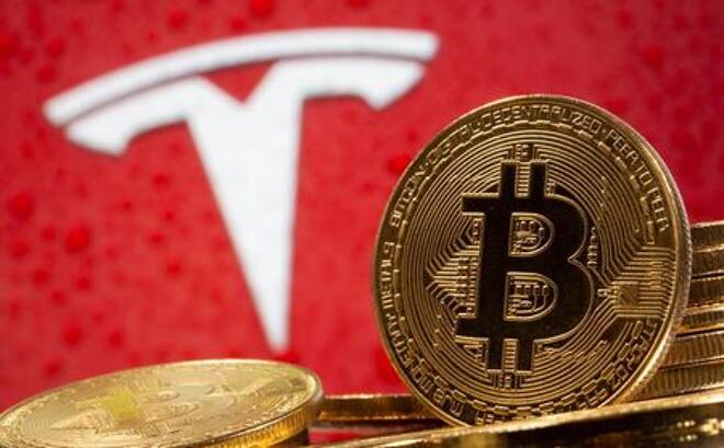 FILE PHOTO: Representations of virtual currency Bitcoin are seen in front of Tesla logo in this illustration taken, February 9, 2021. REUTERS/Dado Ruvic/Illustration