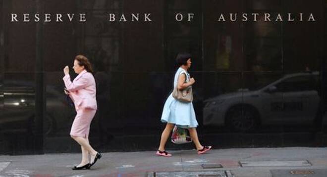 Two women walk next to the Reserve Bank