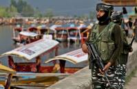 Policial indiano faz guarda em Dal Lake, um famoso ponto turístico em Srinagar