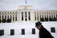 Homem caminha em frente à sede do Federal Reserve em Washington