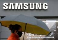 Una mujer con mascarilla pasa por delante de una tienda de Samsung en el centro de Kiev