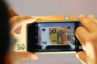 Imagen de archivo de un periodista sacando una foto de un billete de 50 euros en la sede del Banco Central Europeo (BCE) en Fráncfort