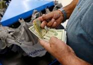 Imagen de archivo de un cliente contando dólares en un supermercado Walmart de Los Ángeles, EEUU.